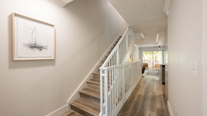 a hallway with wooden floors and stairs at The Palm Haven