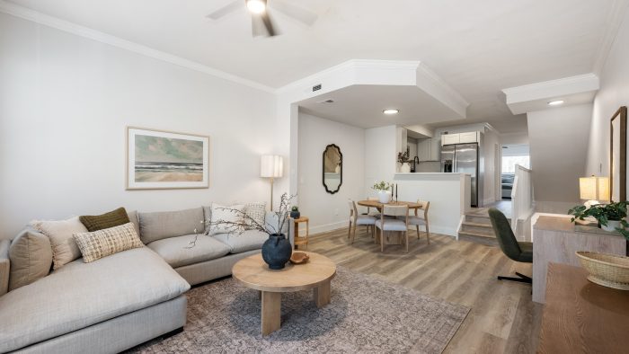 a living room with a ceiling fan and hardwood floors at The Palm Haven